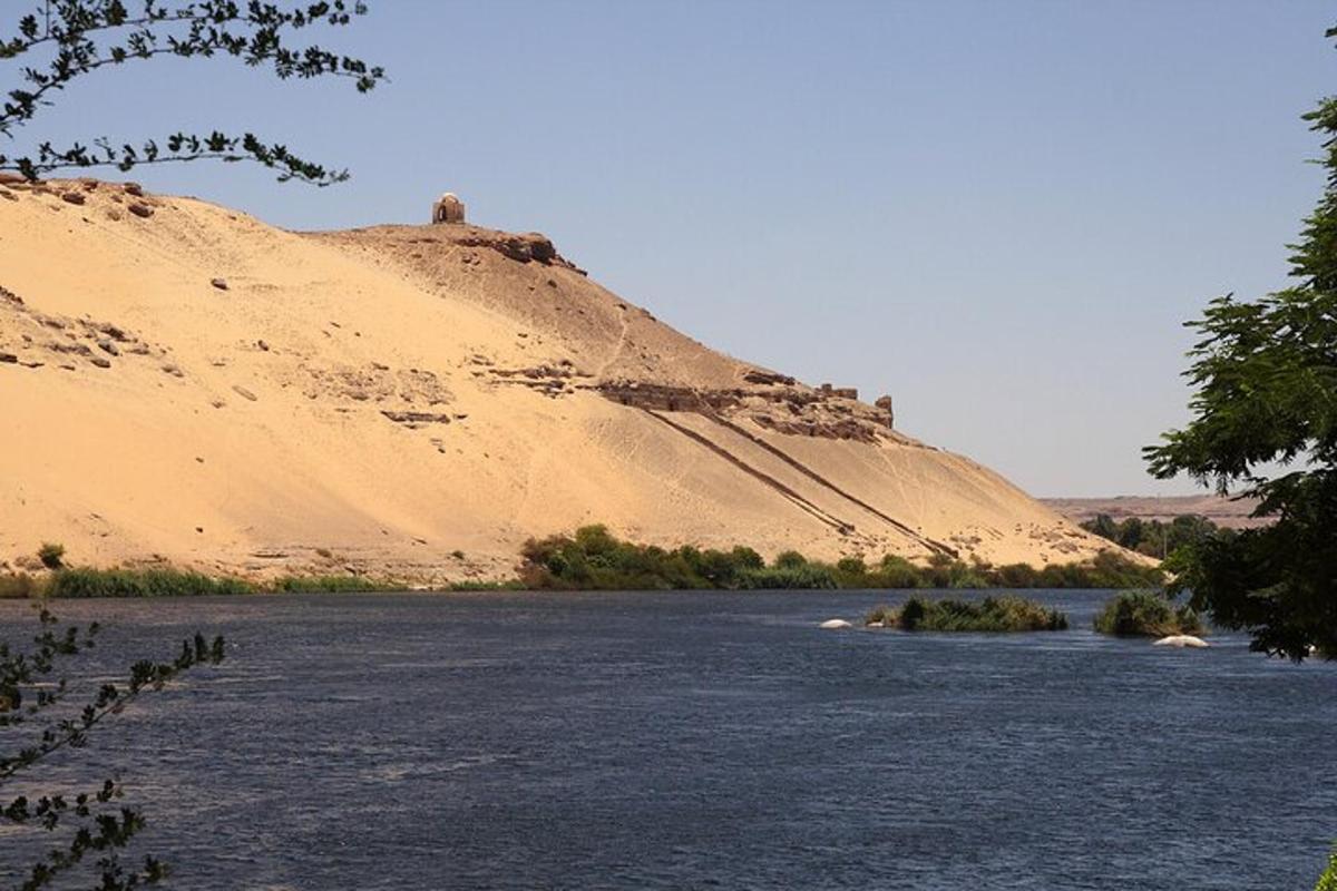 una grande collina sabbiosa accanto a un fiume