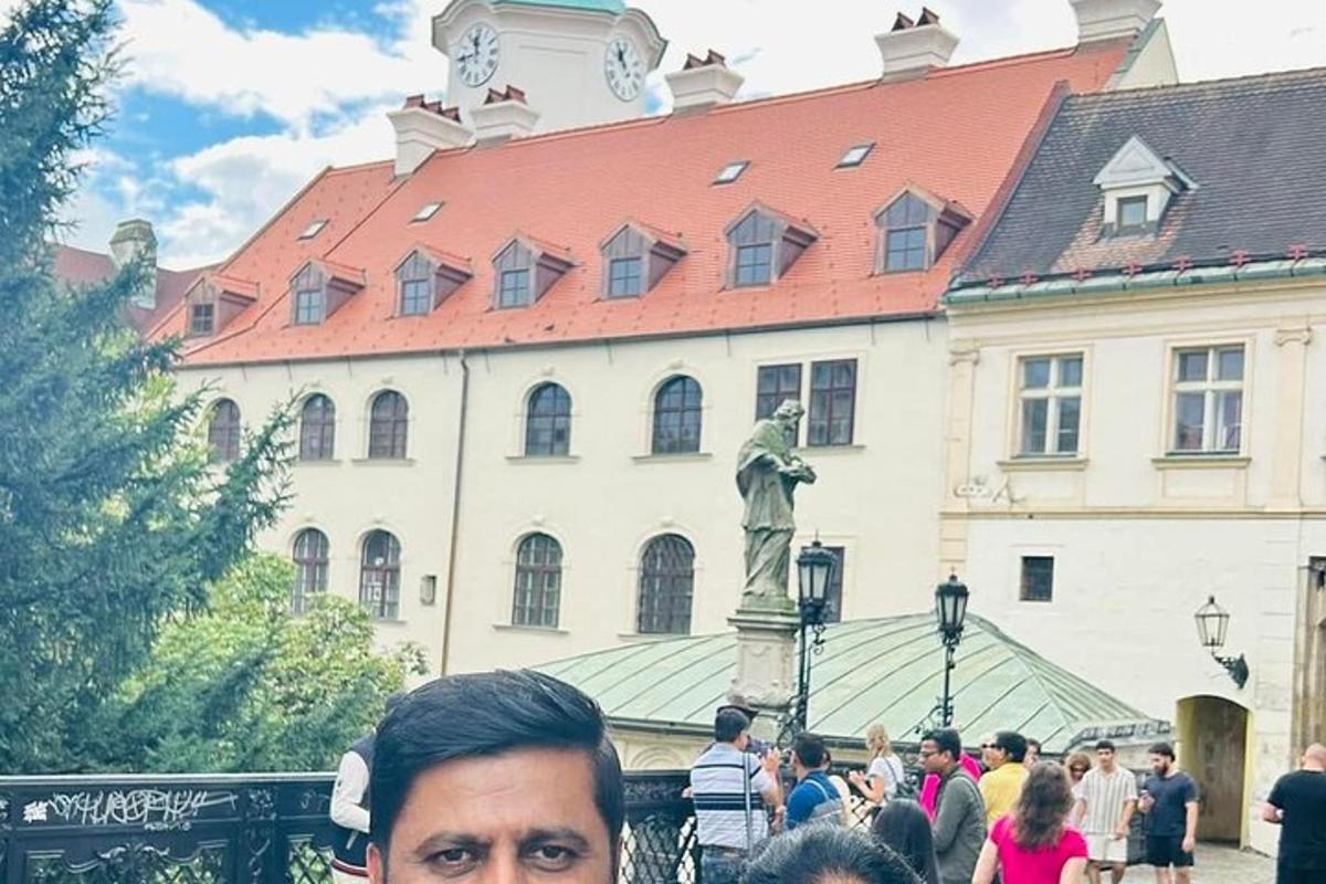 en mann som står foran en bygning med en statue