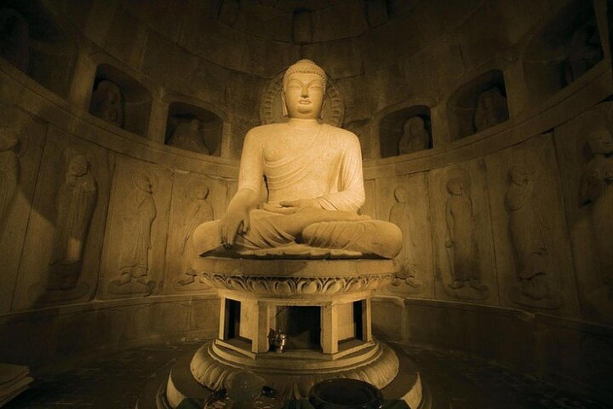 uma estátua sentada em um pedestal em uma sala