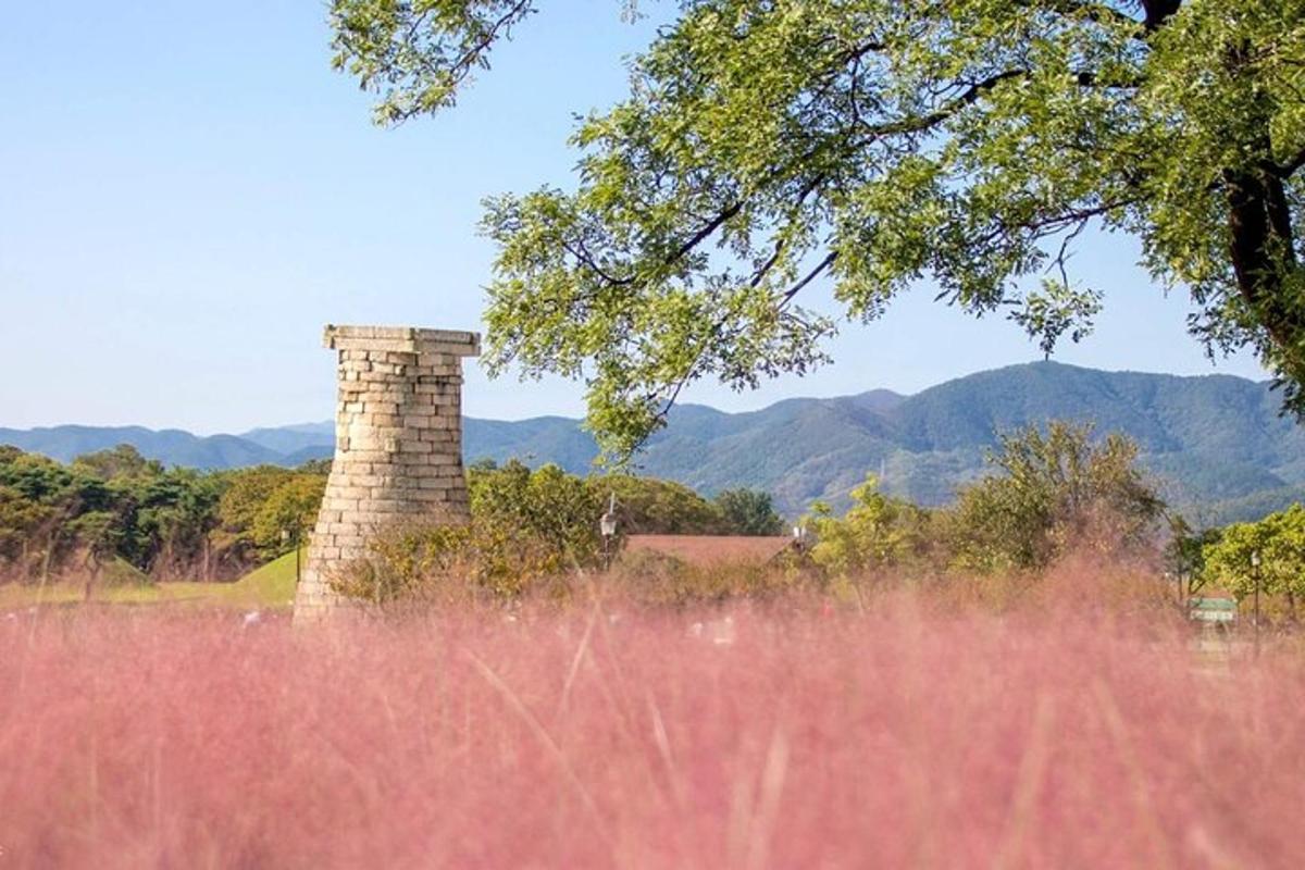 uma chaminé de tijolos em um campo com montanhas ao fundo