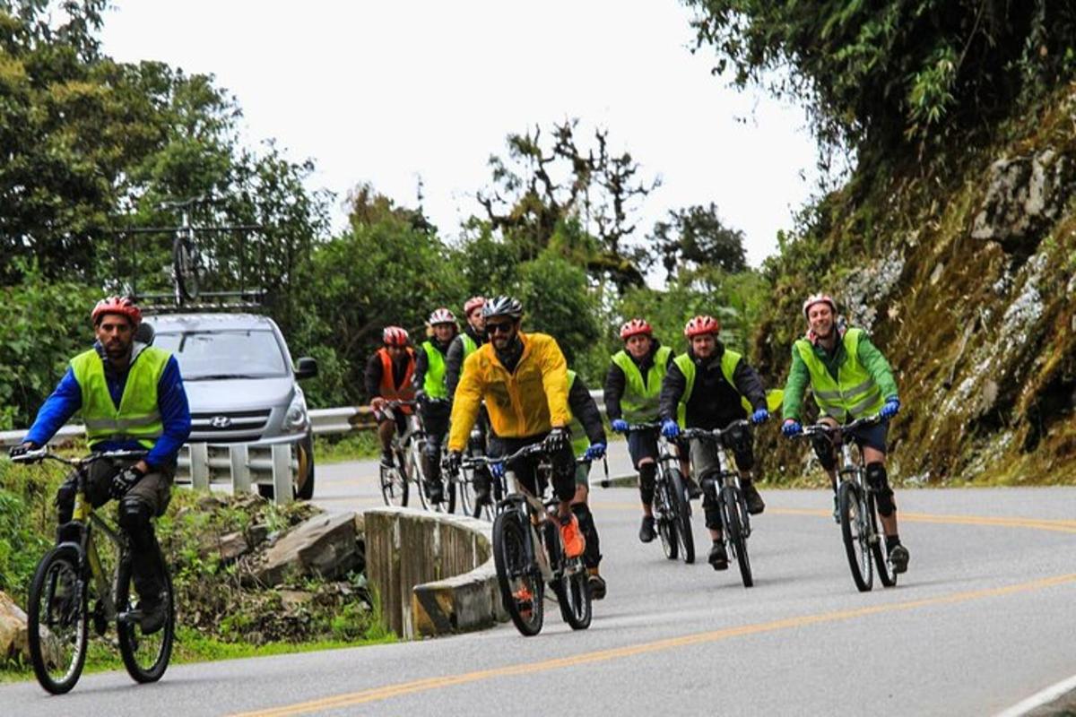 eine Gruppe von Menschen, die mit dem Fahrrad eine Straße entlangfahren