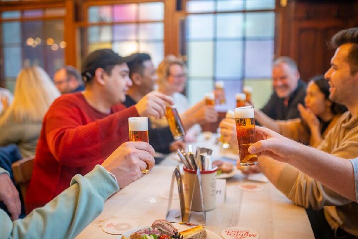 skupina lidí sedících kolem stolu a pijících pivo