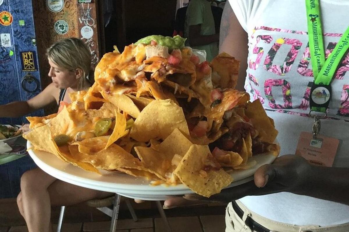 eine Person, die einen Teller Nachos hält