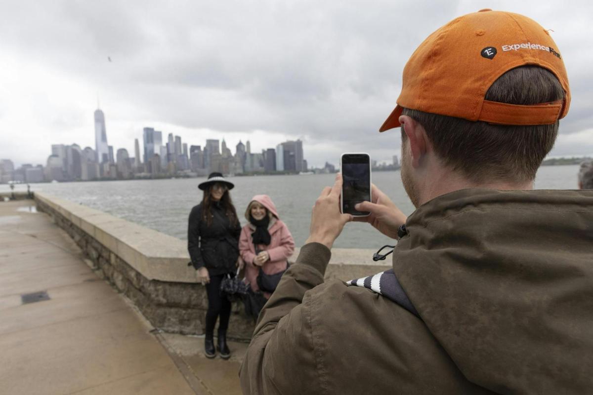 un uomo che scatta una foto della città con il suo cellulare