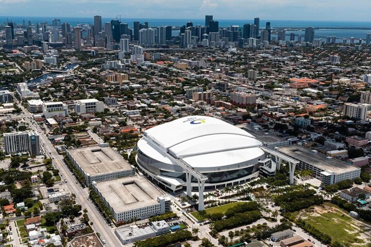 an aerial view of a large white stadium with a city