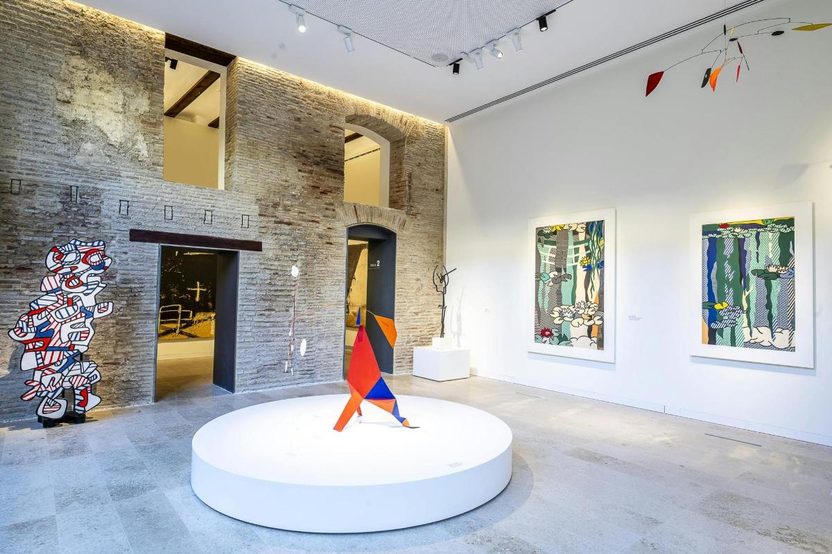 Un museo con una escultura sobre una mesa blanca en una habitación.