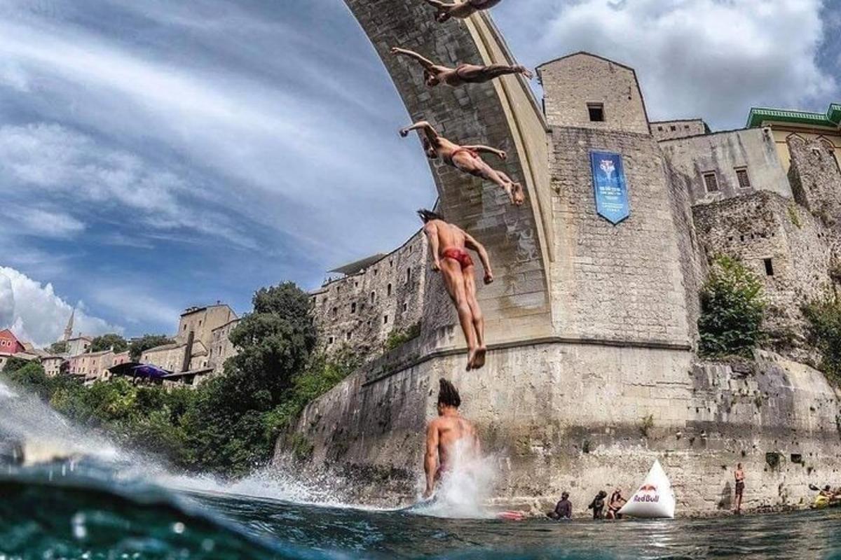 Δύο άτομα πηδούν στο νερό μπροστά από ένα κτίριο