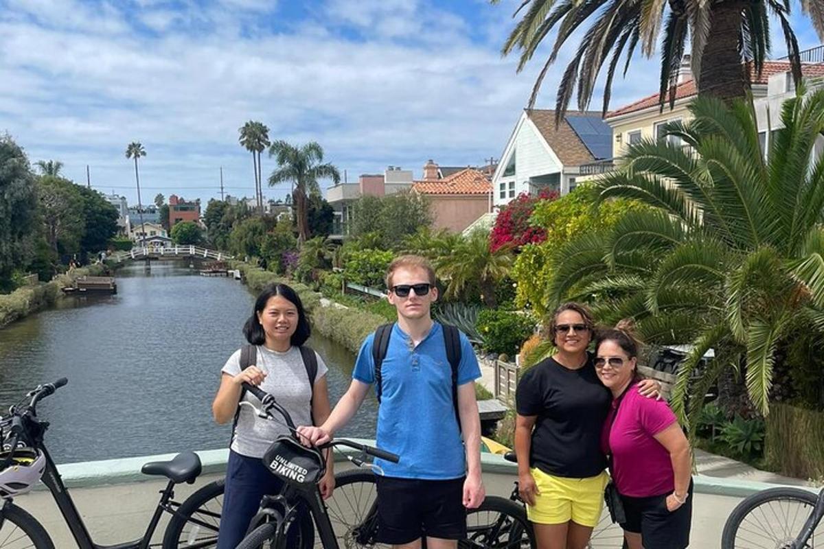 a group of people standing next to a river with bikes