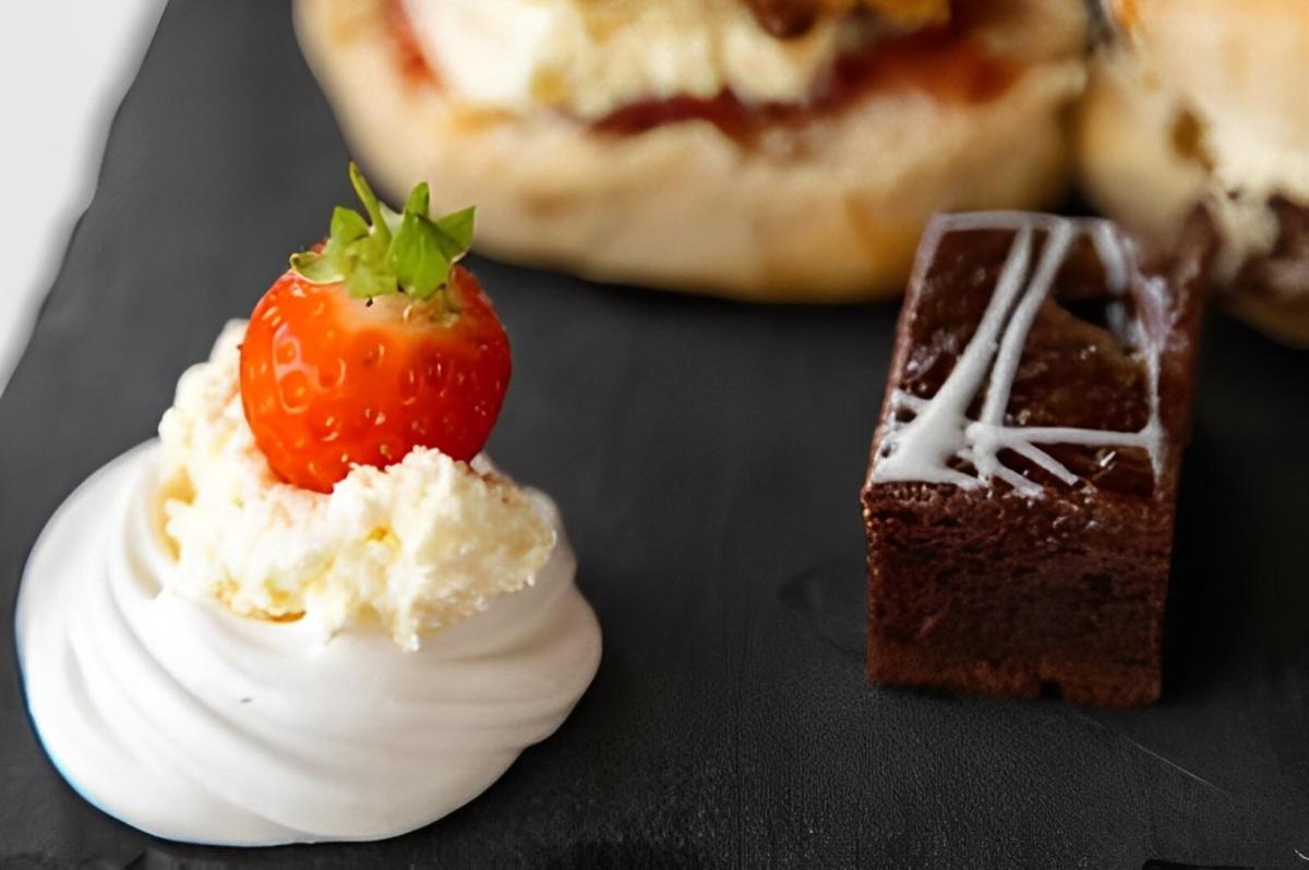 un plat de postres amb una maduixa a sobre