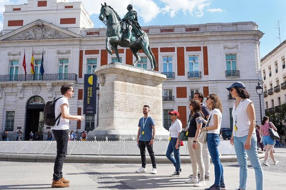un grup de oameni care stau în fața unei statui