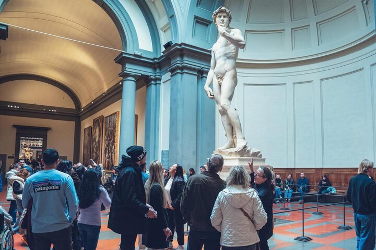 uma multidão de pessoas olhando para uma estátua em um museu