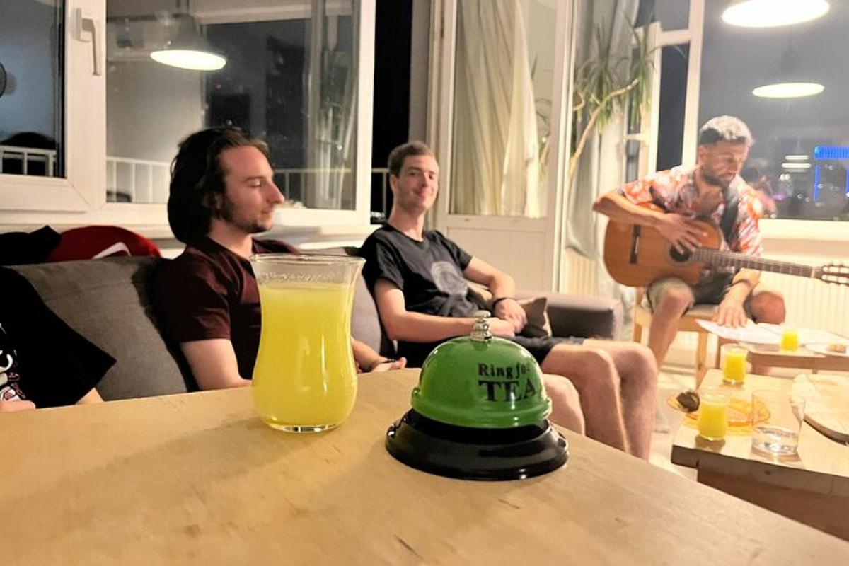 um grupo de homens sentados ao redor de uma mesa com um copo de suco de laranja