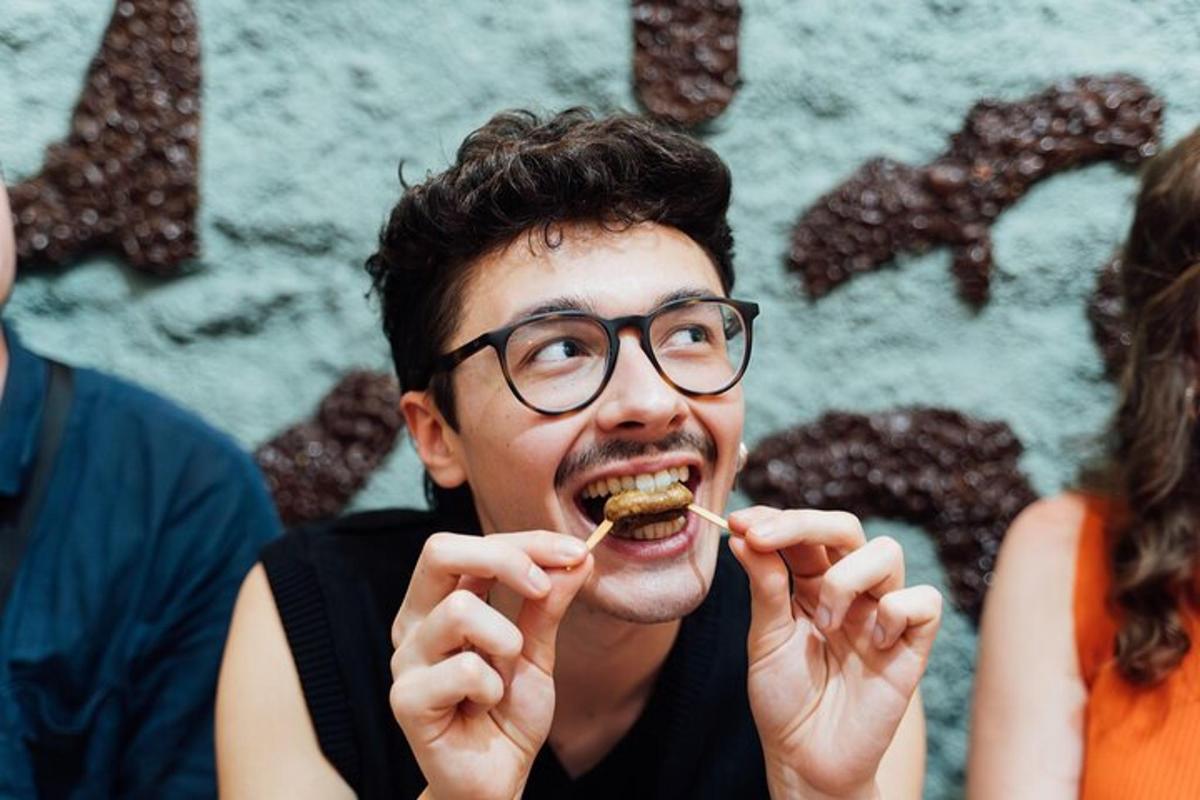 眼鏡をかけた男性が口の中で食べ物を食べている