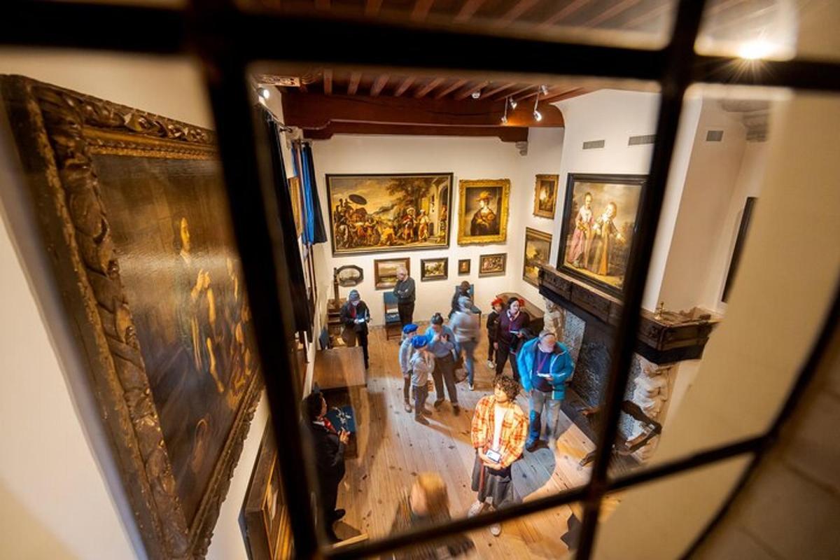 a group of people looking at paintings in a museum
