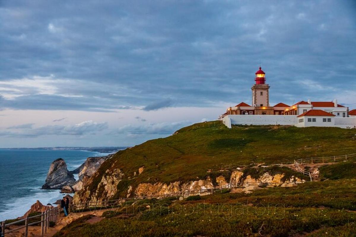 un faro in cima a una collina con l'oceano