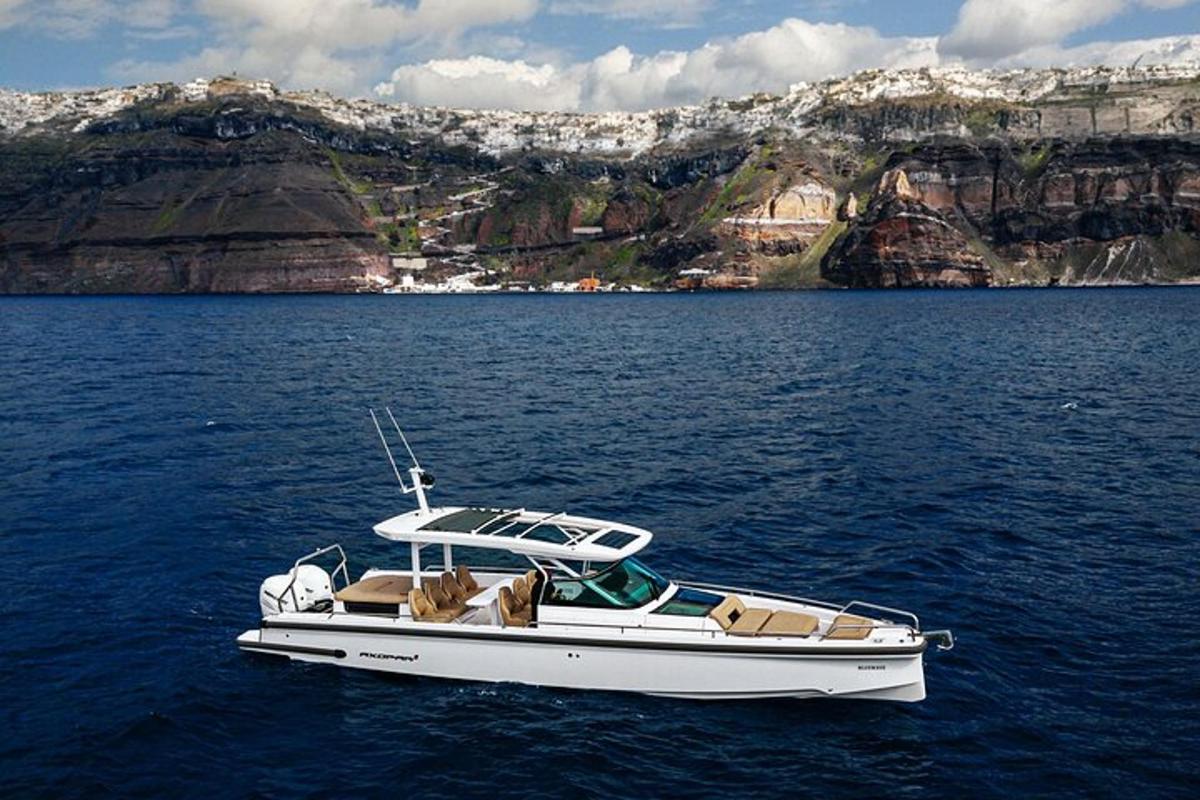 Un barco blanco en el agua cerca de una montaña.