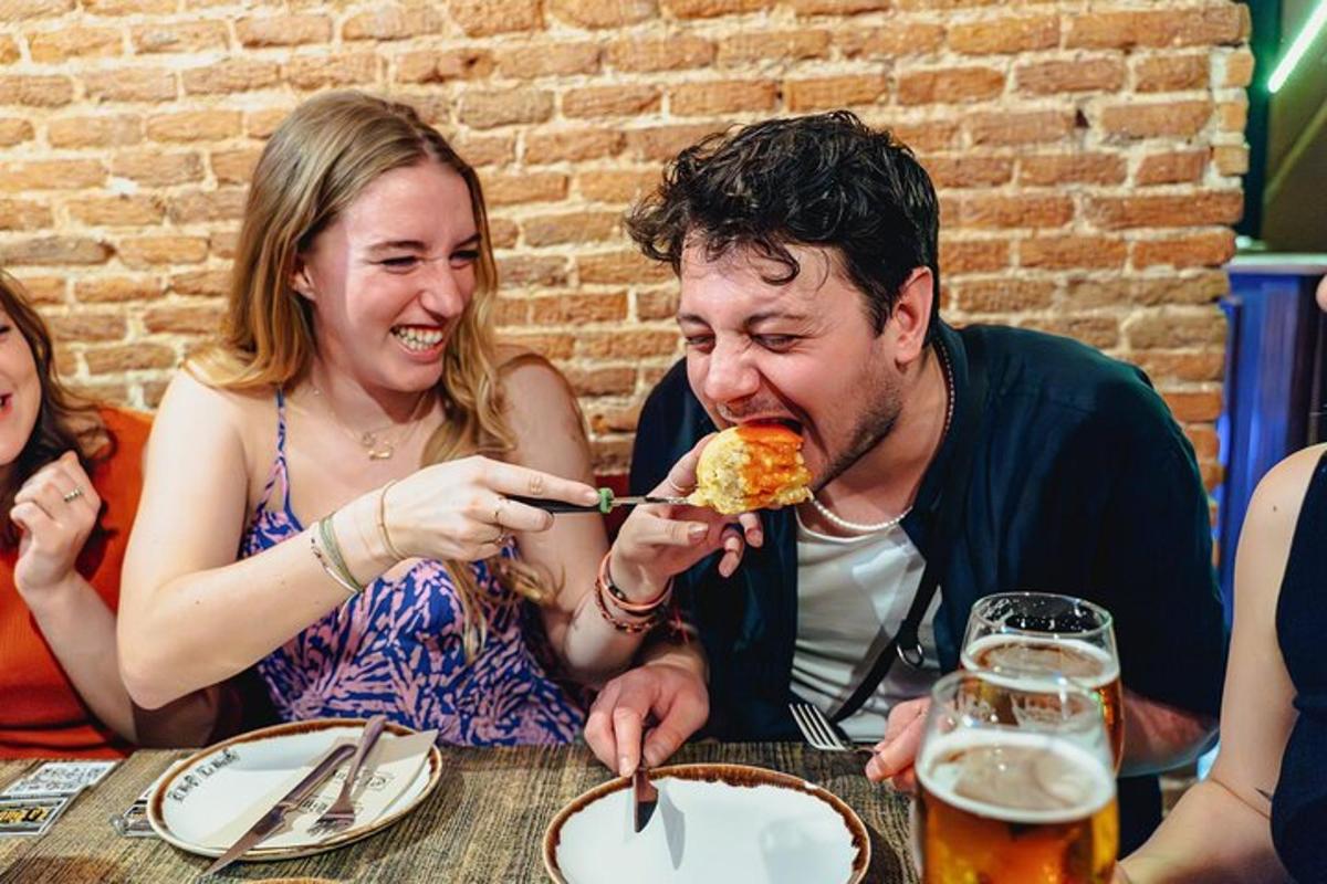 Un hombre y una mujer sentados en una mesa comiendo pizza