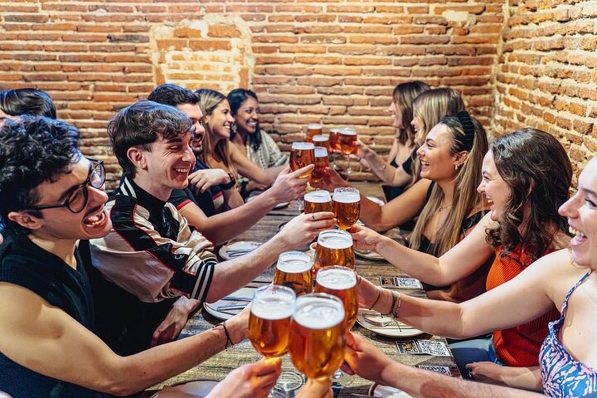skupina ljudi, ki sedijo okoli mize in pijejo pivo