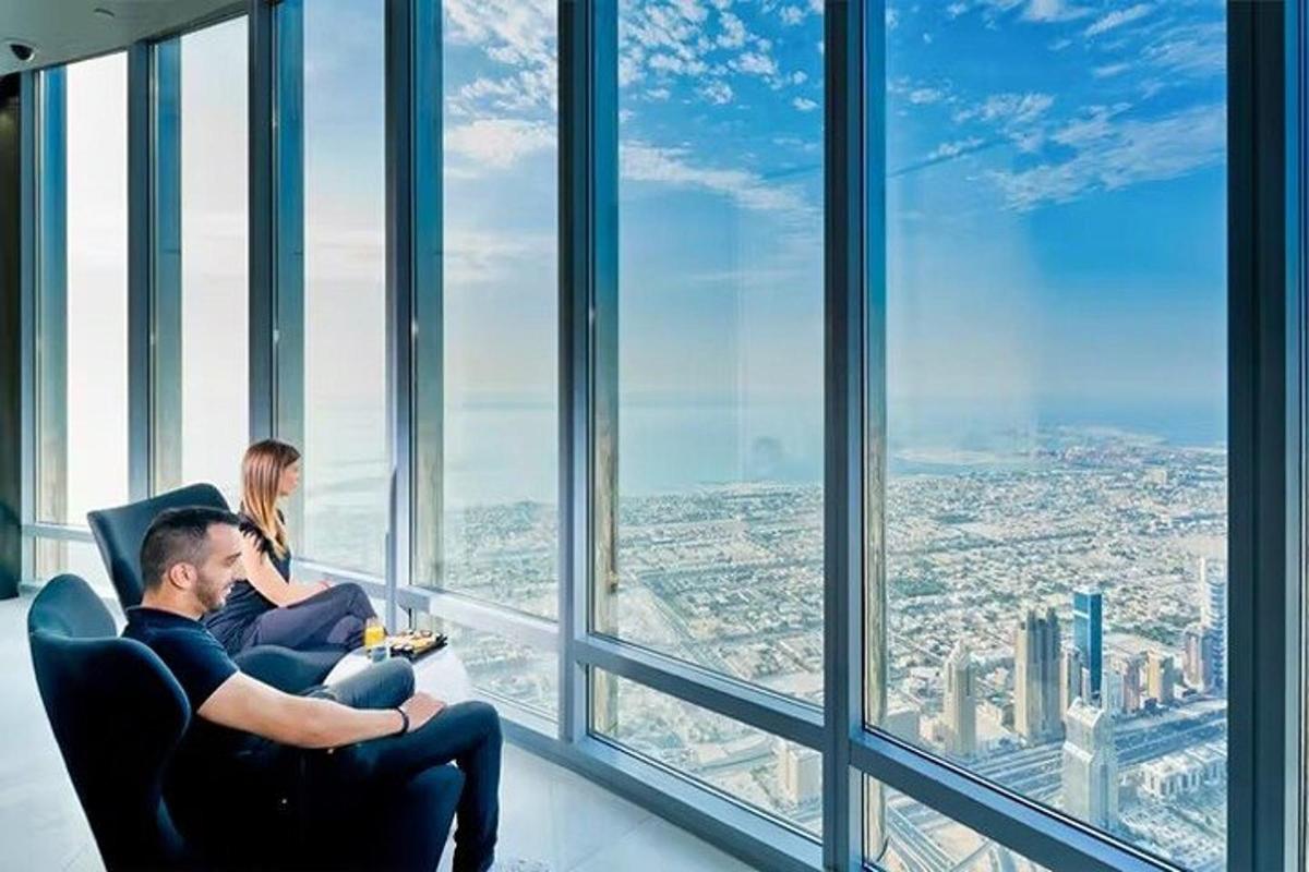a man and a woman sitting in a chair looking out the window