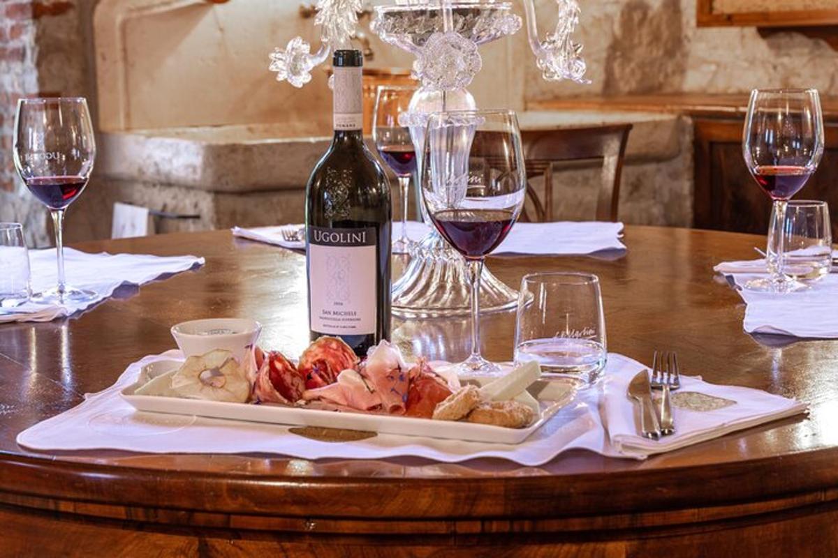 miza s steklenico vina in krožnikom hrane