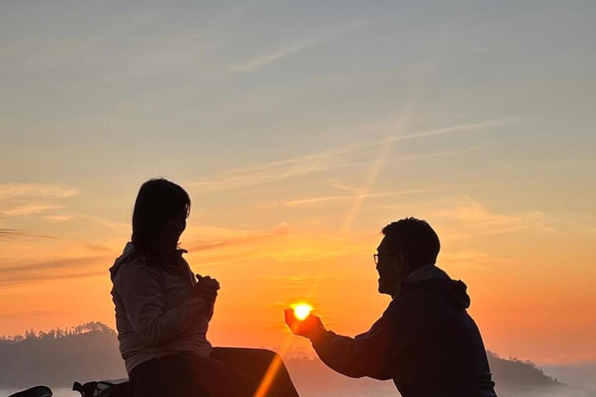 Un hombre y una mujer sentados frente a una puesta de sol