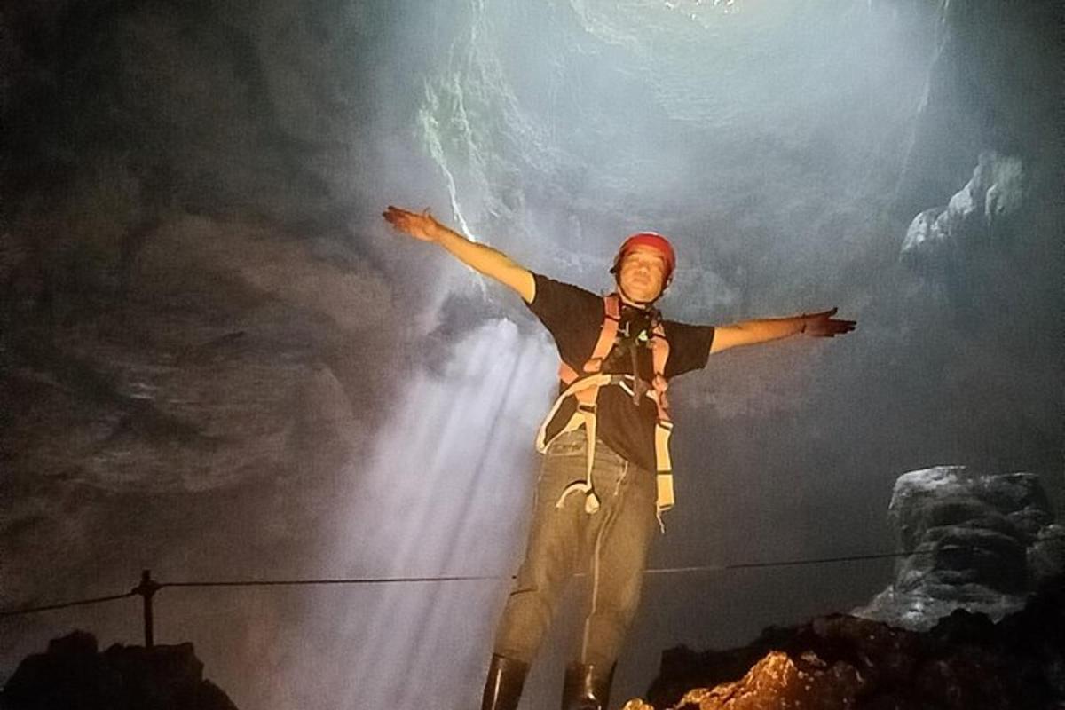 seorang lelaki berdiri di atas wayar dengan tangan dihulurkan