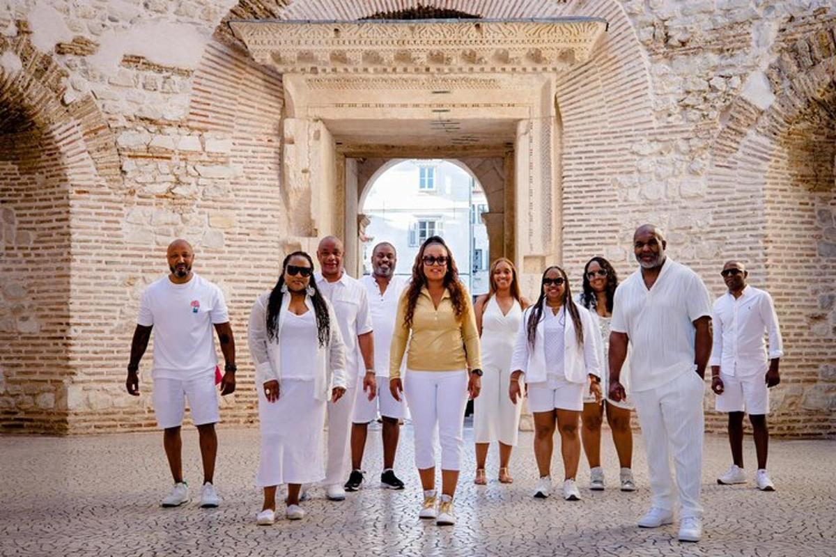 a group of people dressed in white standing in front of a building