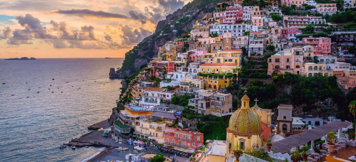 a group of buildings on a hill next to the ocean