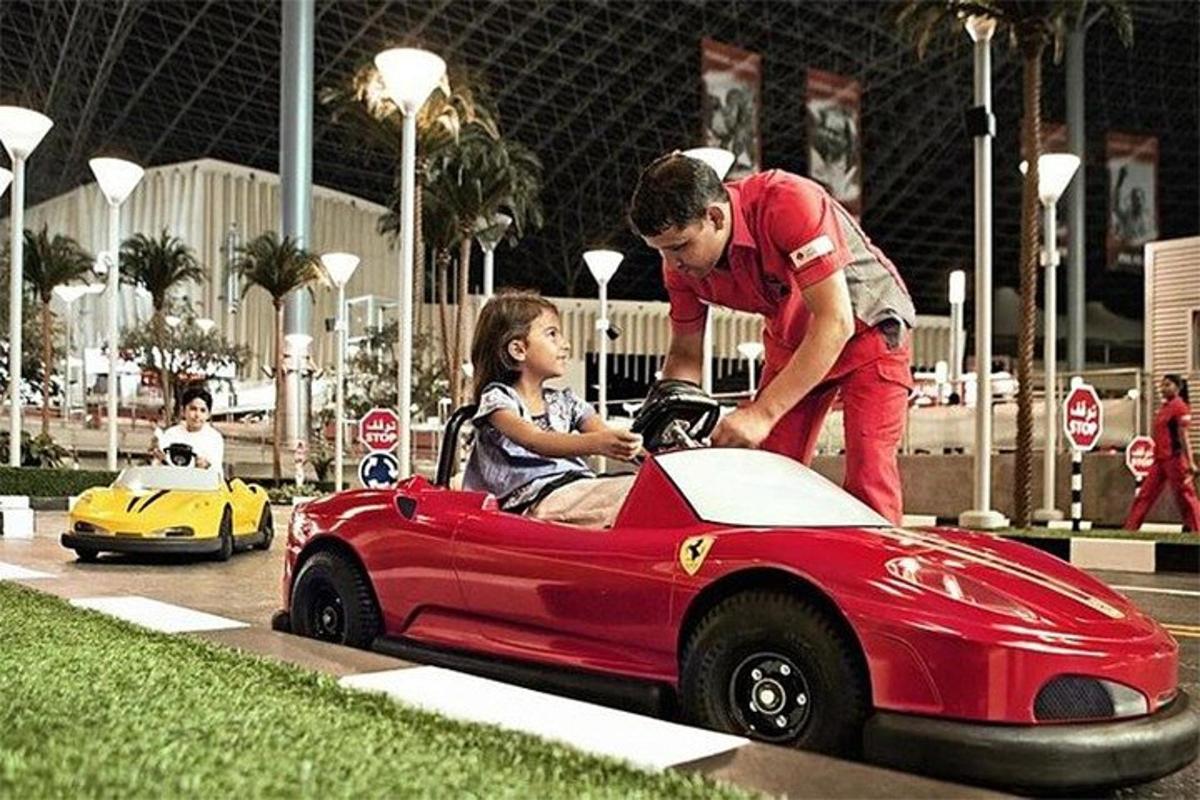 a man and a young girl in a red toy car