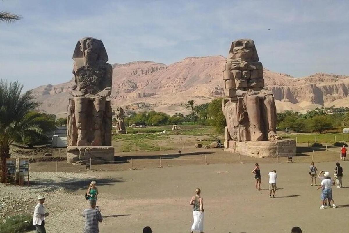 a group of people standing in front of two statues