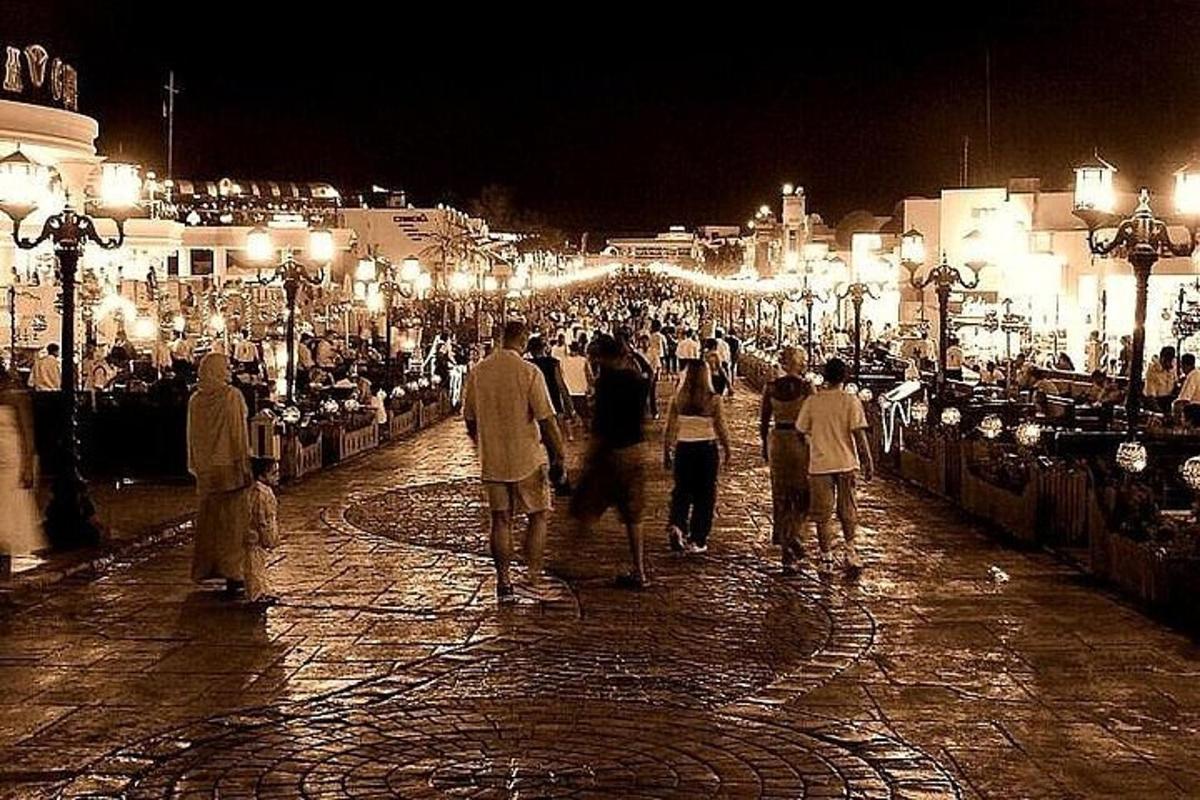 Un grupo de personas caminando por una calle de noche