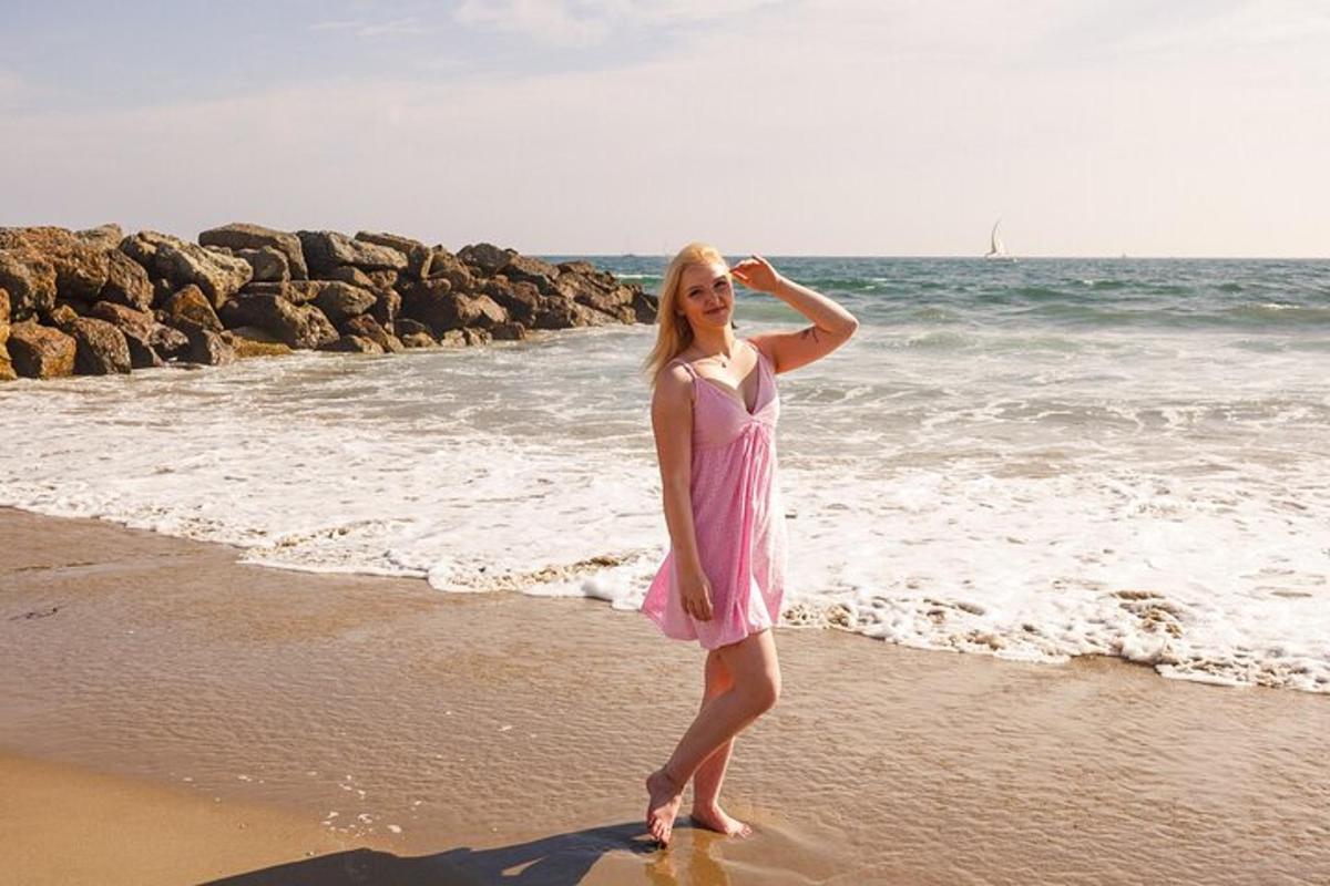 ženska v roza obleki, ki stoji na plaži