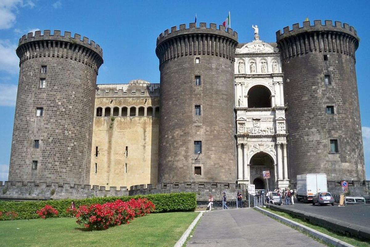 um grande castelo com duas torres com pessoas na frente dele