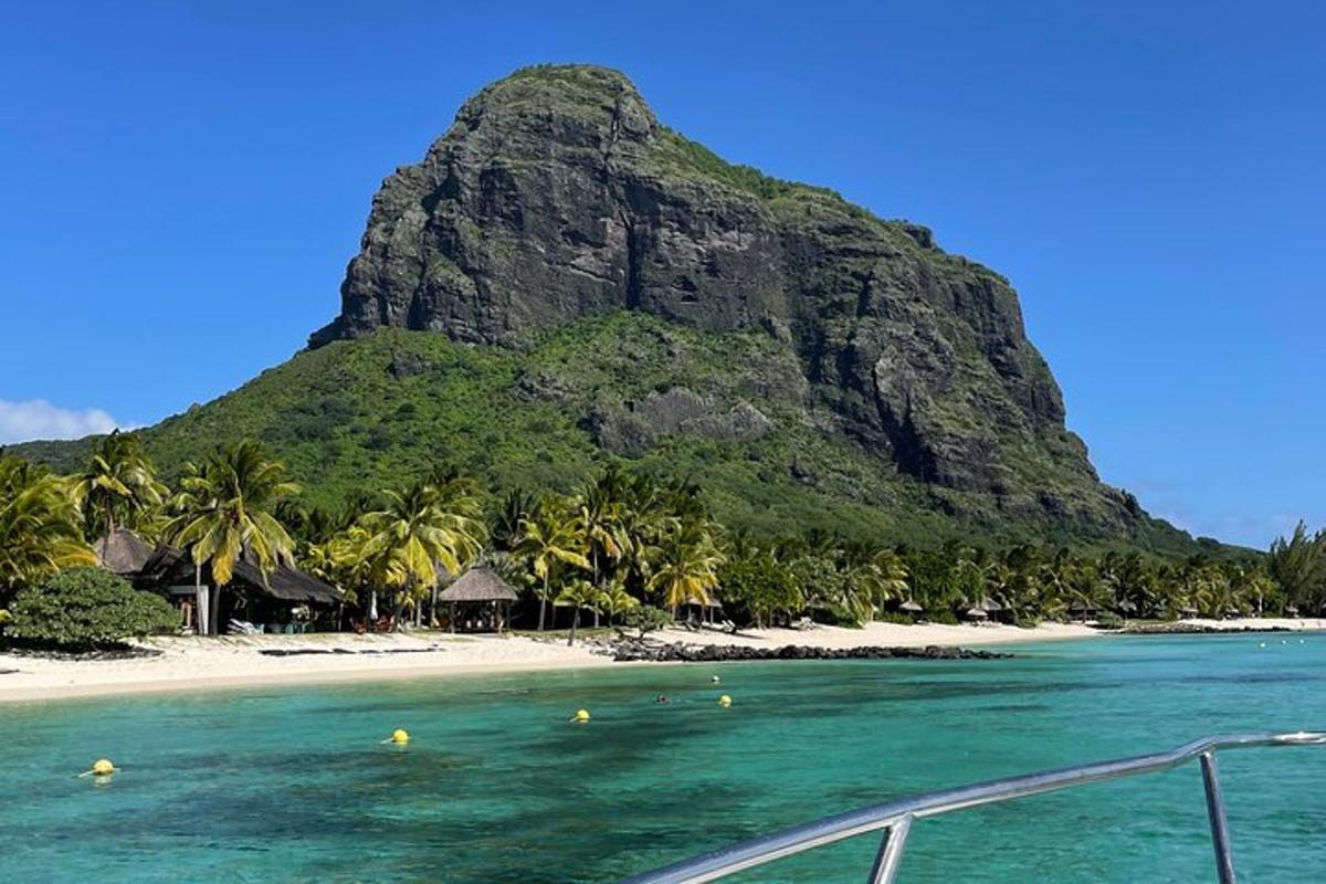 bot di dalam air di sebelah pantai dengan gunung