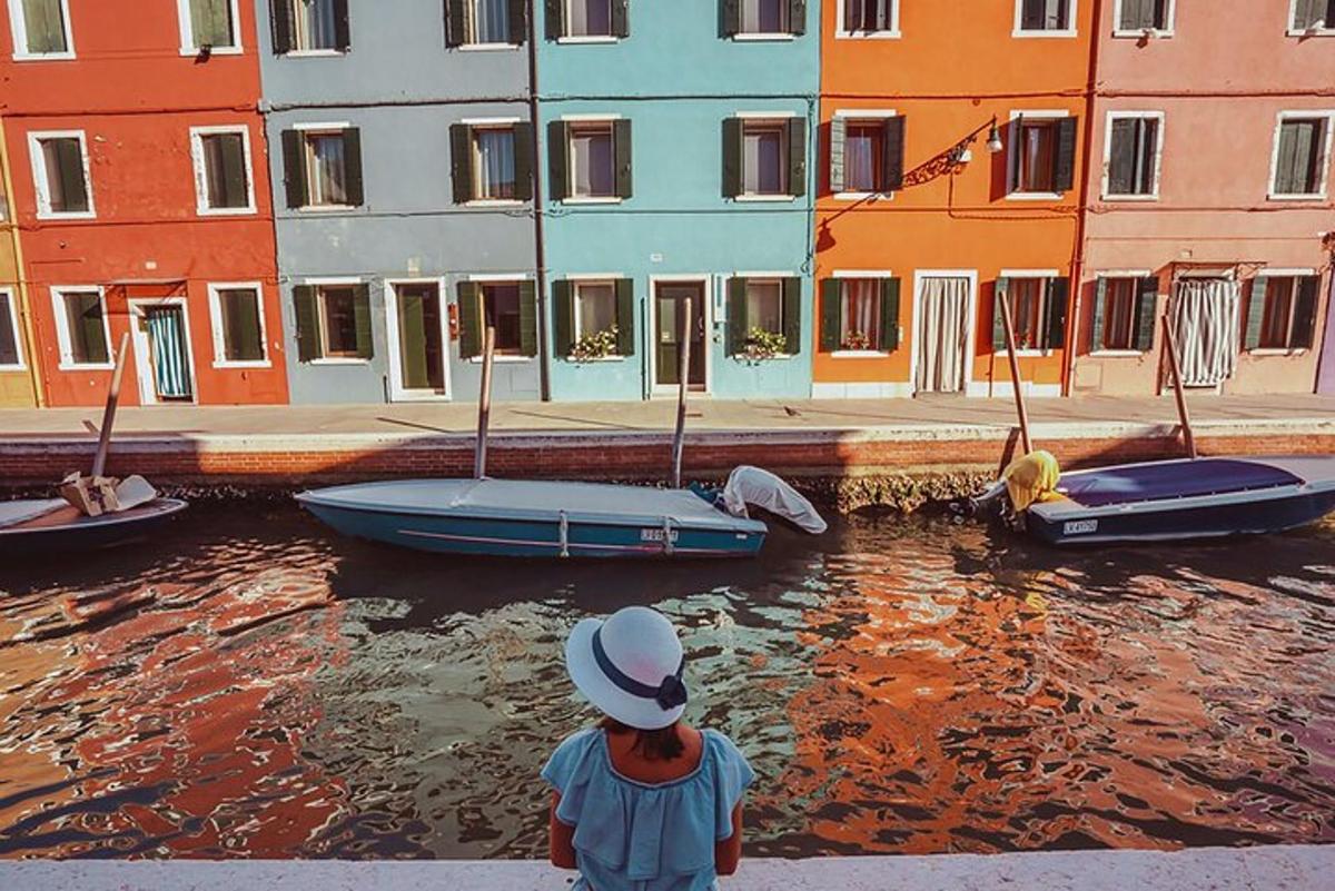 un ragazzino in piedi su una sporgenza che guarda le barche in acqua