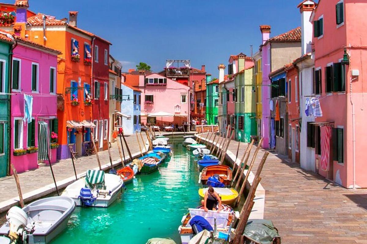 un gruppo di barche in un canale con edifici colorati
