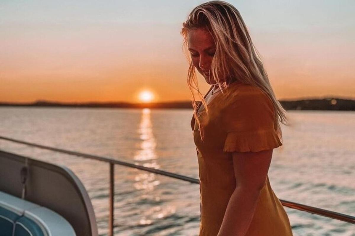 a woman in a yellow dress standing on a boat