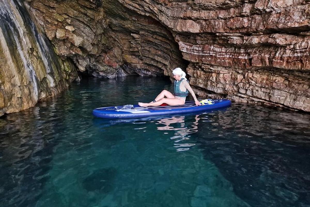 una donna seduta su una tavola da paddle in acqua