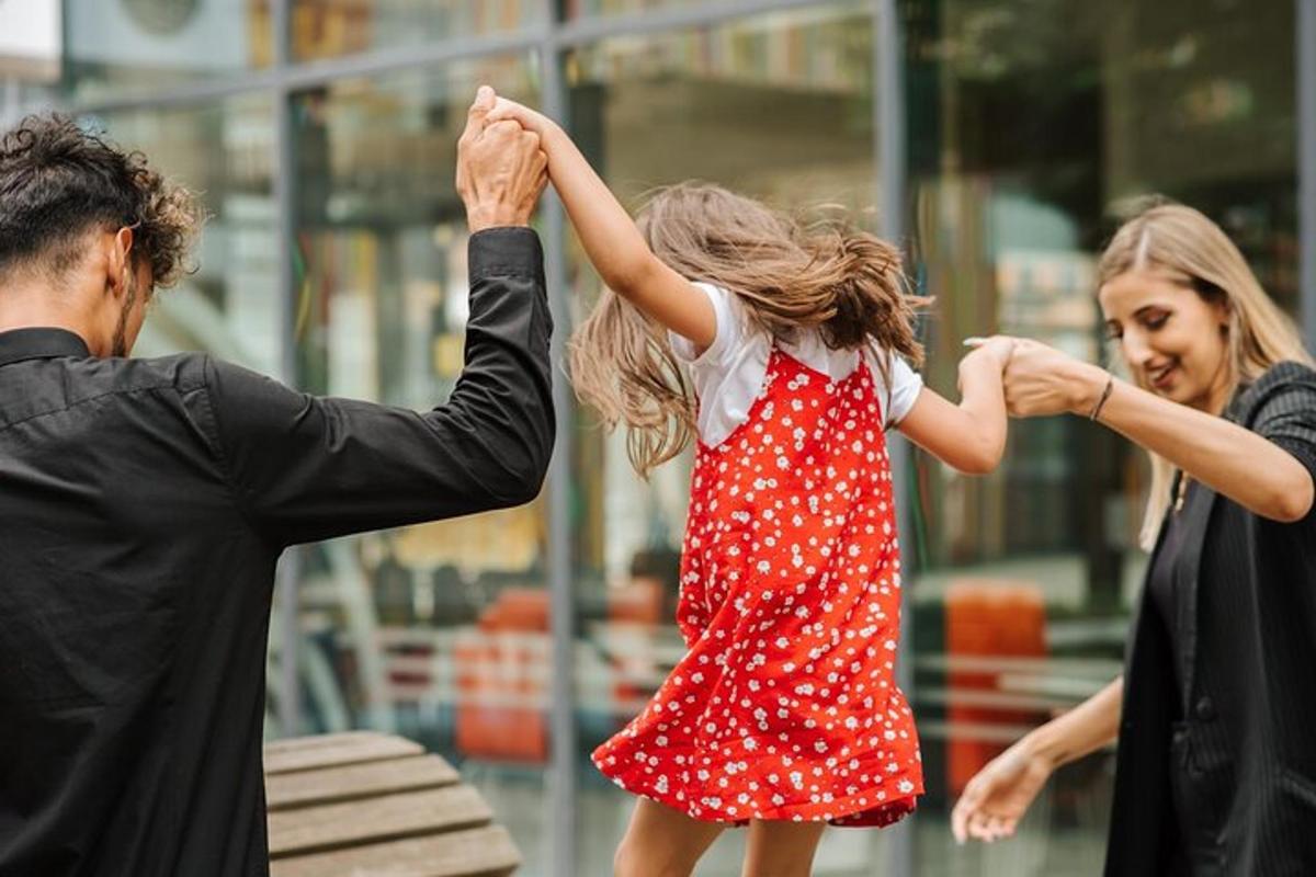 Maður og lítil stúlka dansa við konu