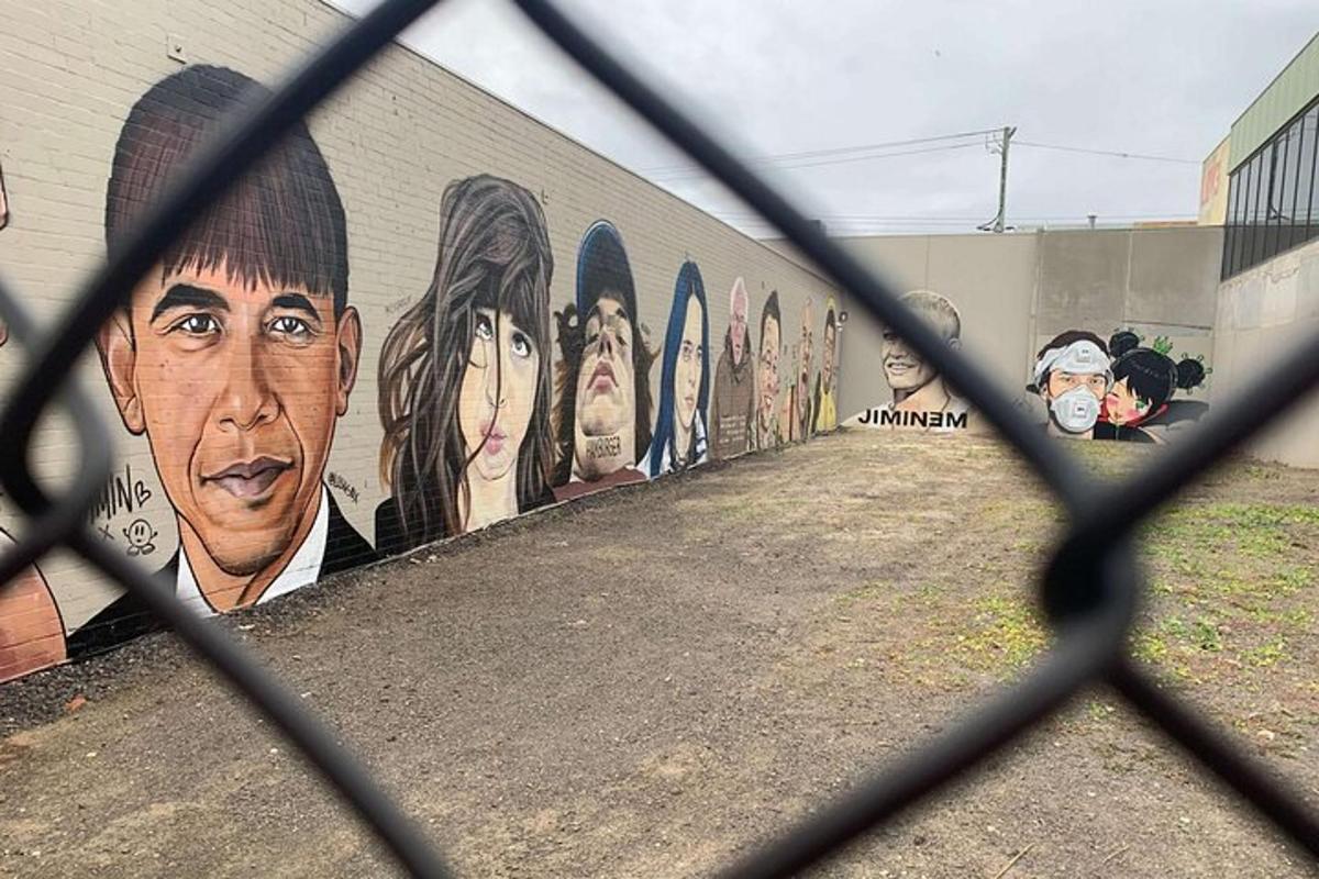 Mural znanih ljudi na steni za ograjo
