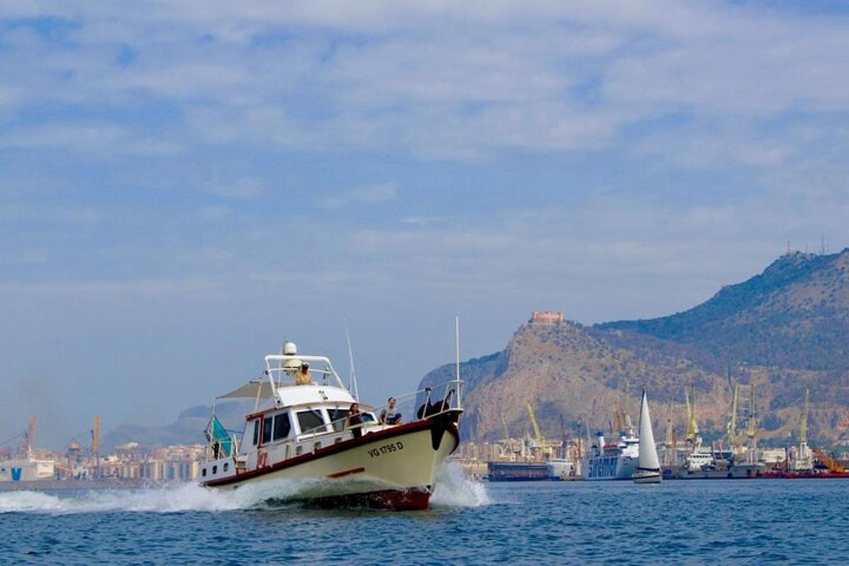 Un barco en el agua con montañas al fondo.