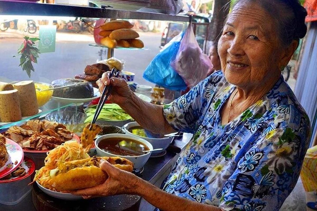 una donna anziana che tiene in mano un piatto di cibo