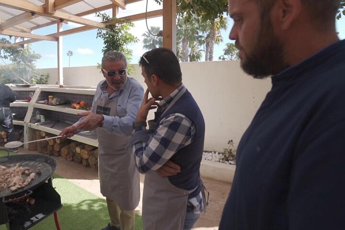 un gruppo di uomini in piedi attorno a una griglia