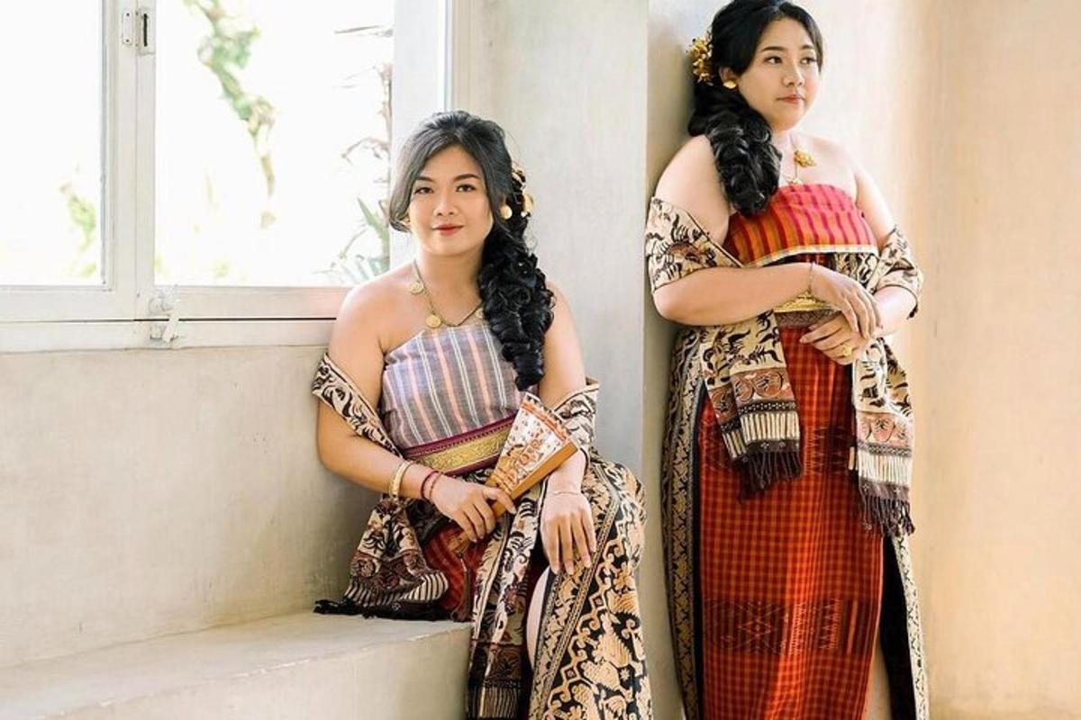 two women are sitting on a window sill