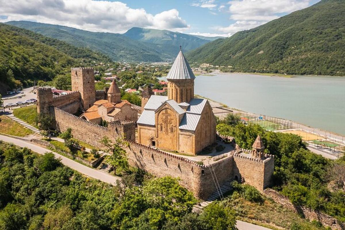 стара будівля з вежею на пагорбі поруч з водоймою