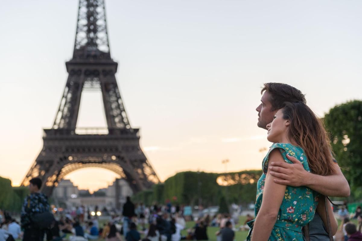 a couple standing in front of the eiffel tower