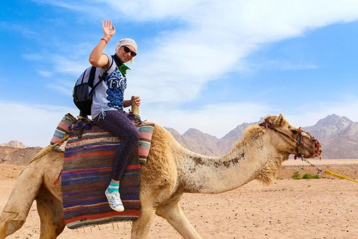 un hombre montado en un camello en el desierto