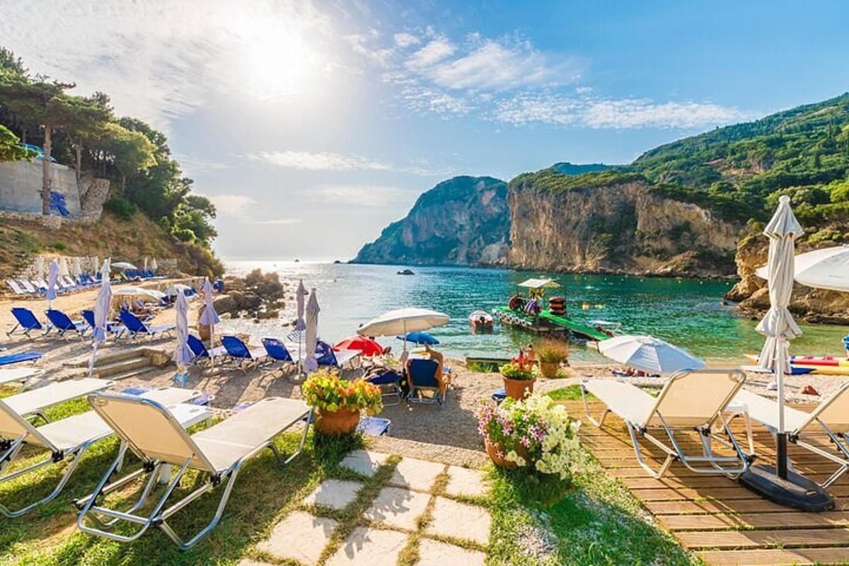 a beach with chairs and umbrellas and the water