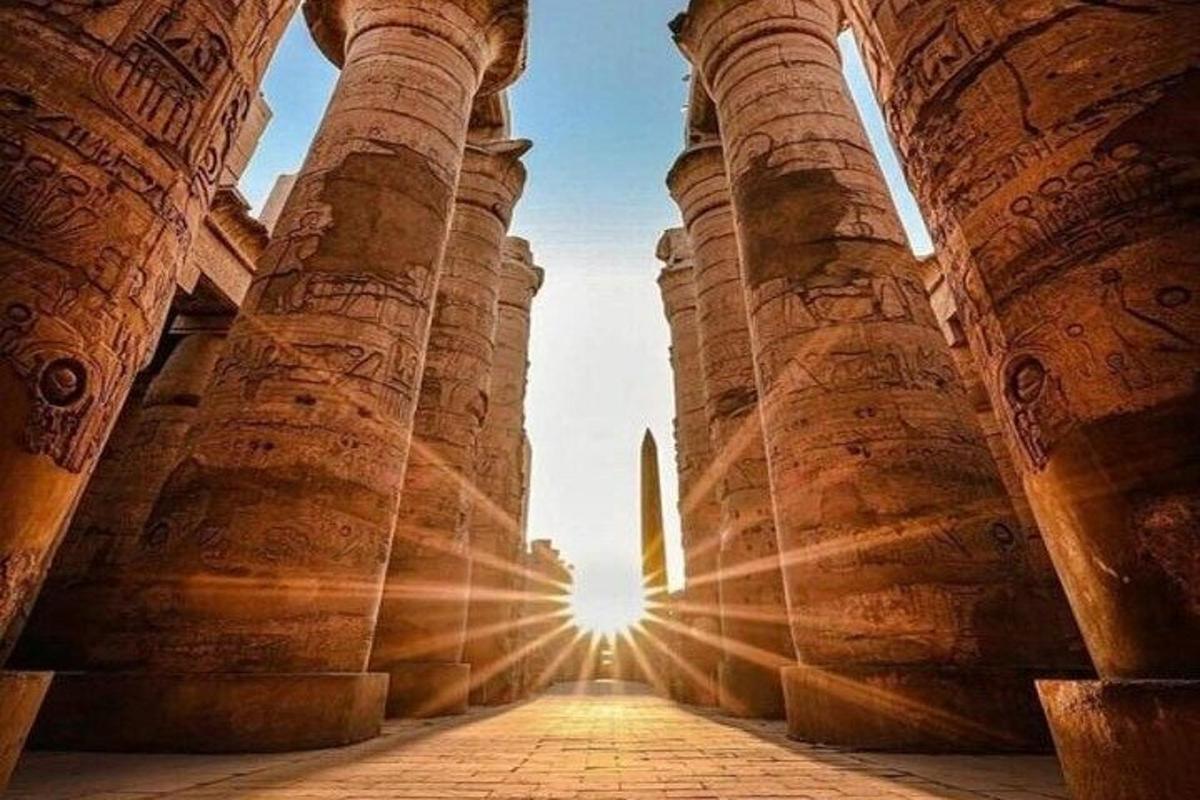 una vista del sole che splende attraverso le colonne di un edificio