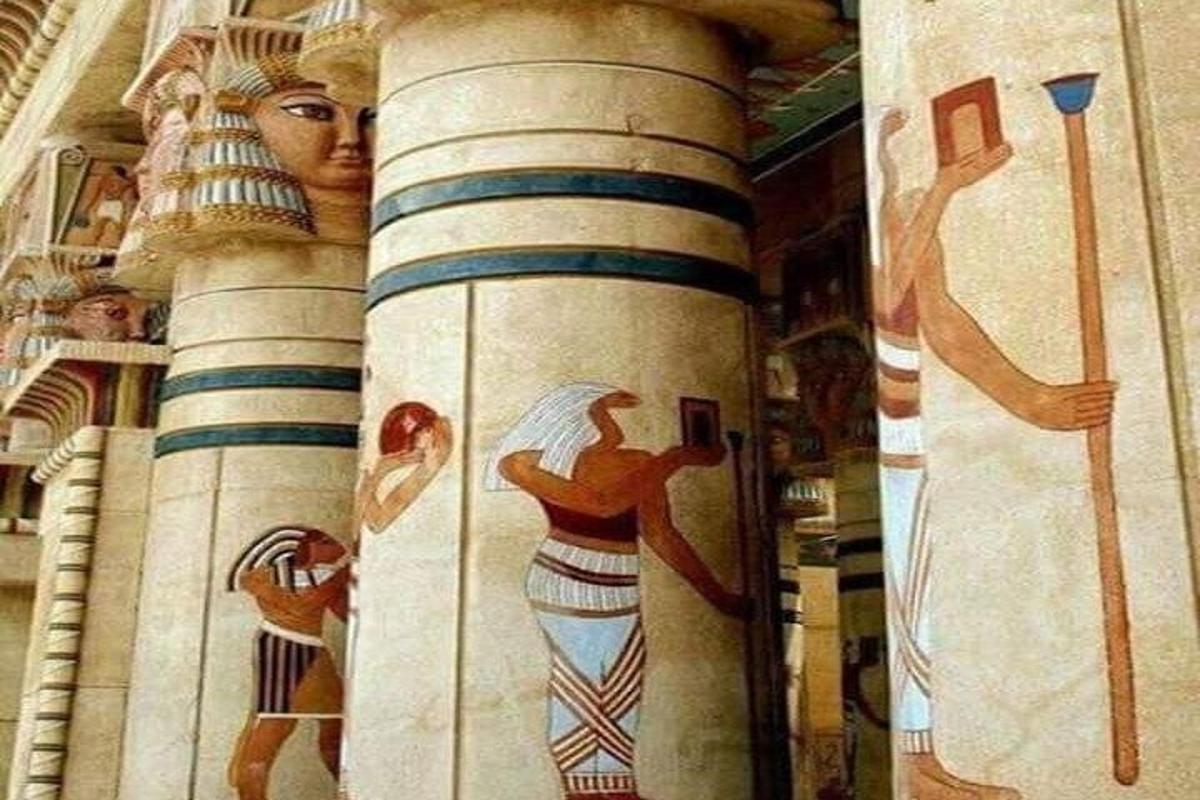 una columna amb pintures de dones al costat d'un edifici